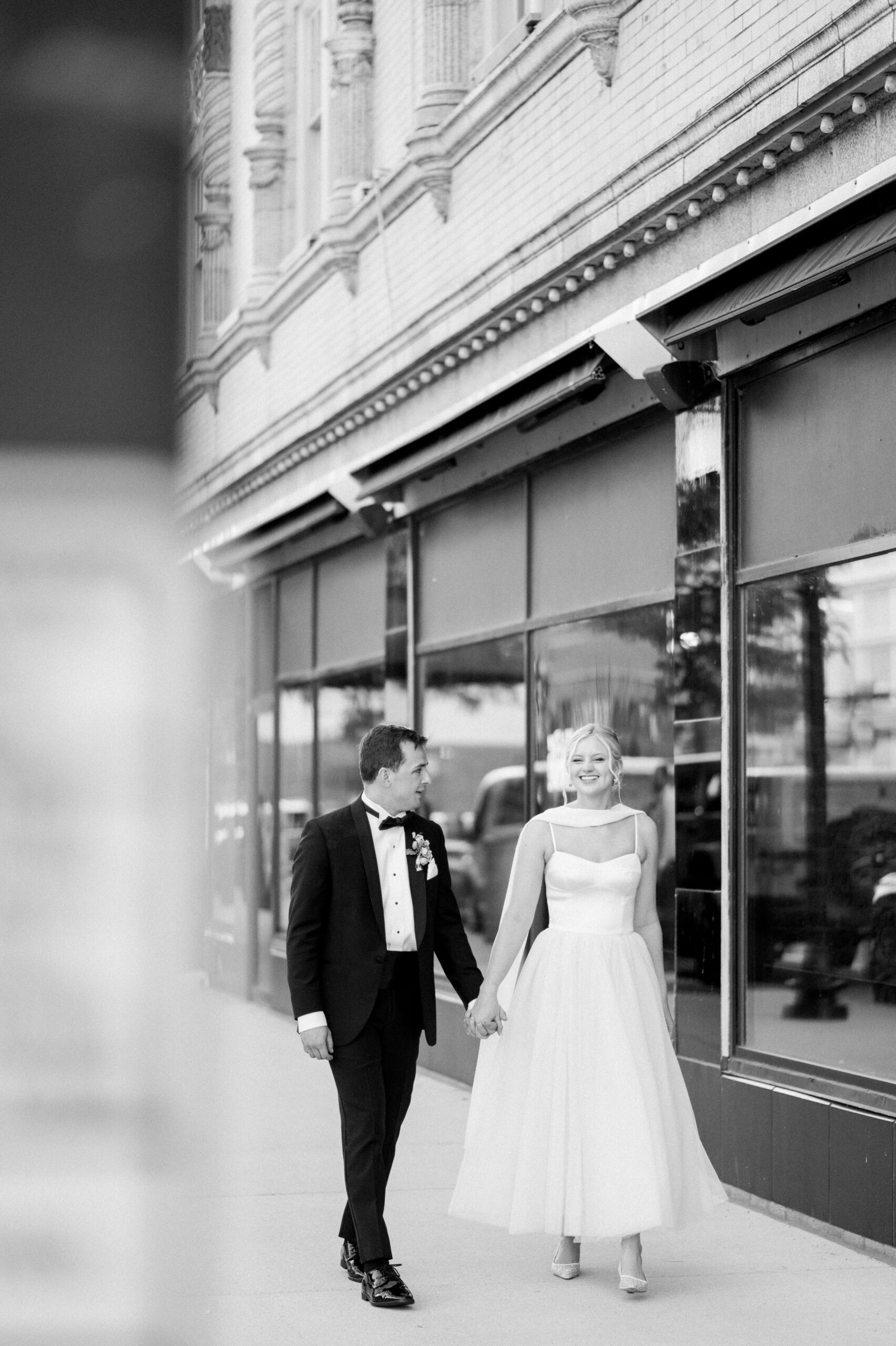 Bride and groom walking in downtown south bend, black and white photo