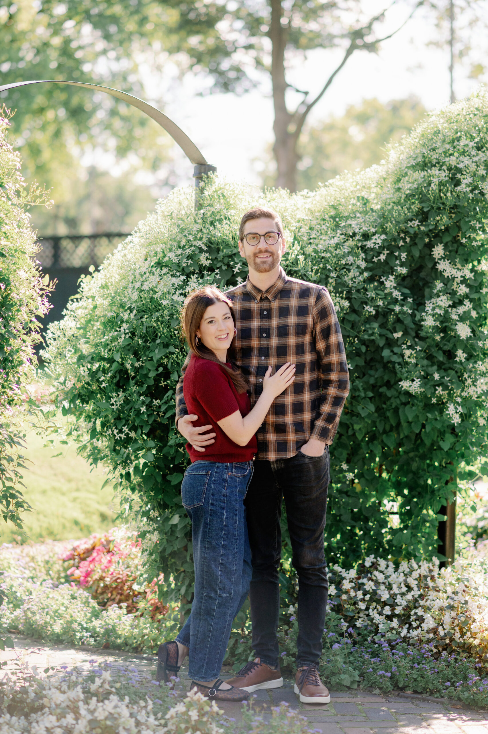 Couple Looking at the camera in fall attire in a jasmine garden in south bend, indiana