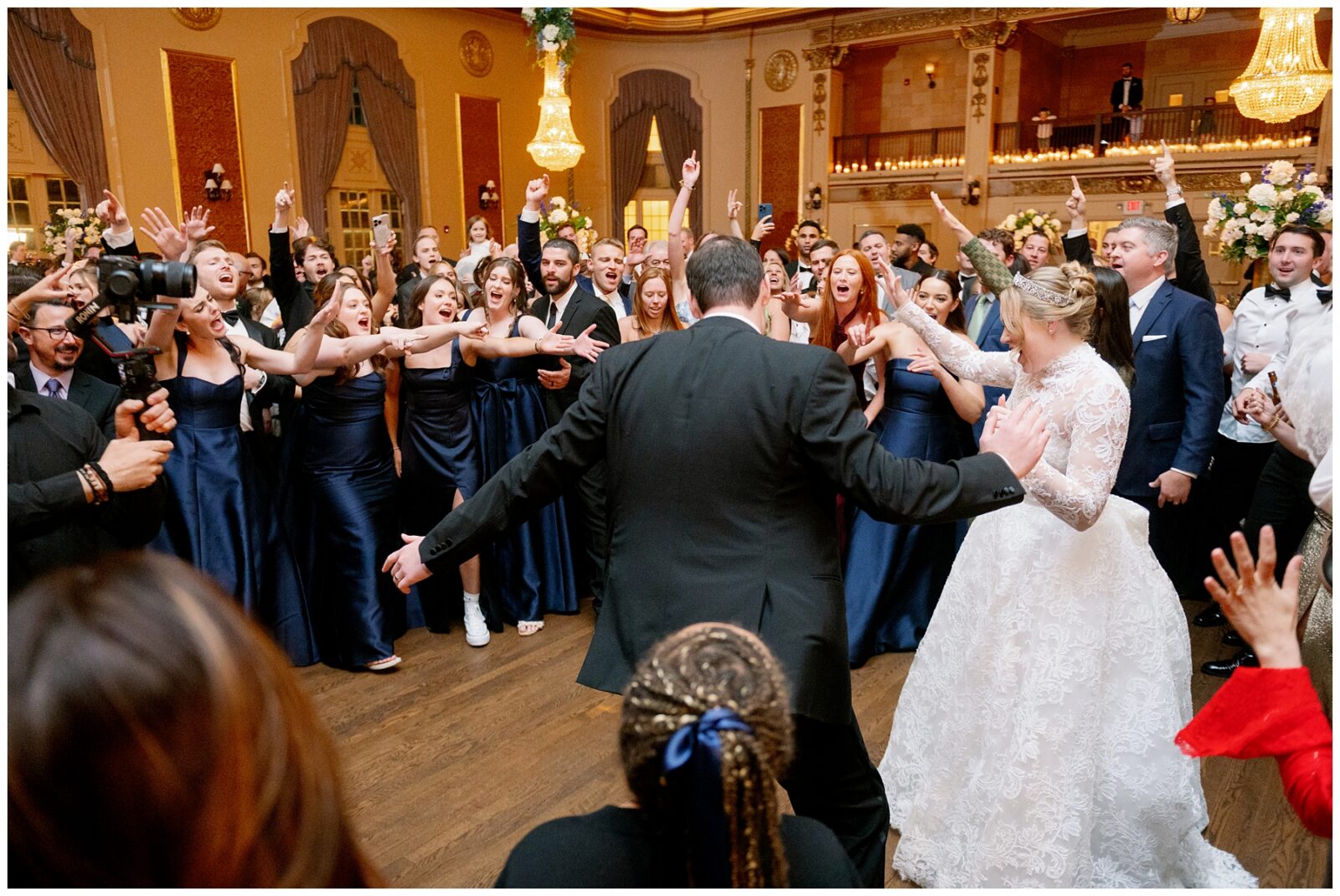 A bride and groom dance with their guests at their Notre Dame wedding reception.