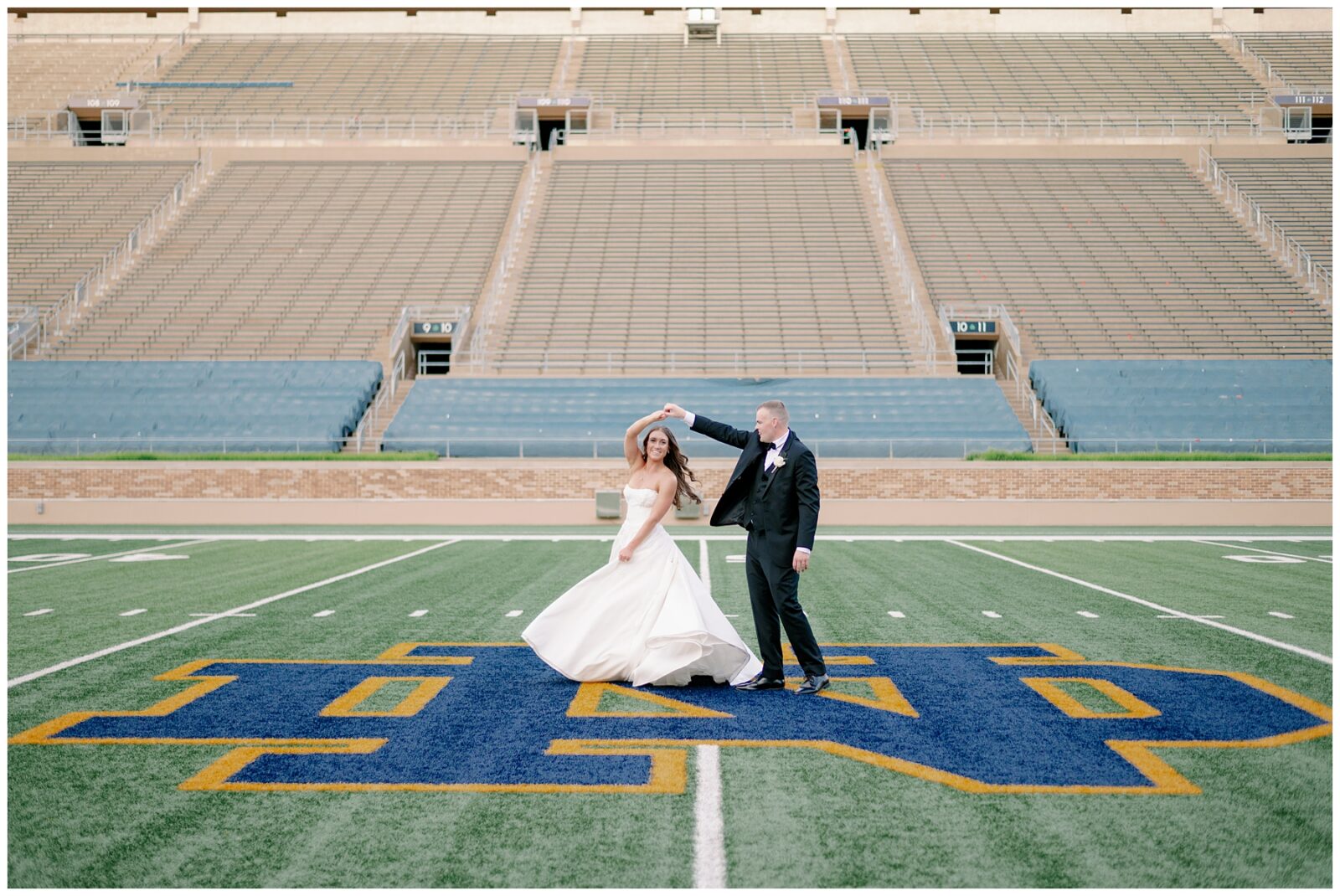 Bride twirling on Notre Dame midfield logo during wedding portraits at stadium