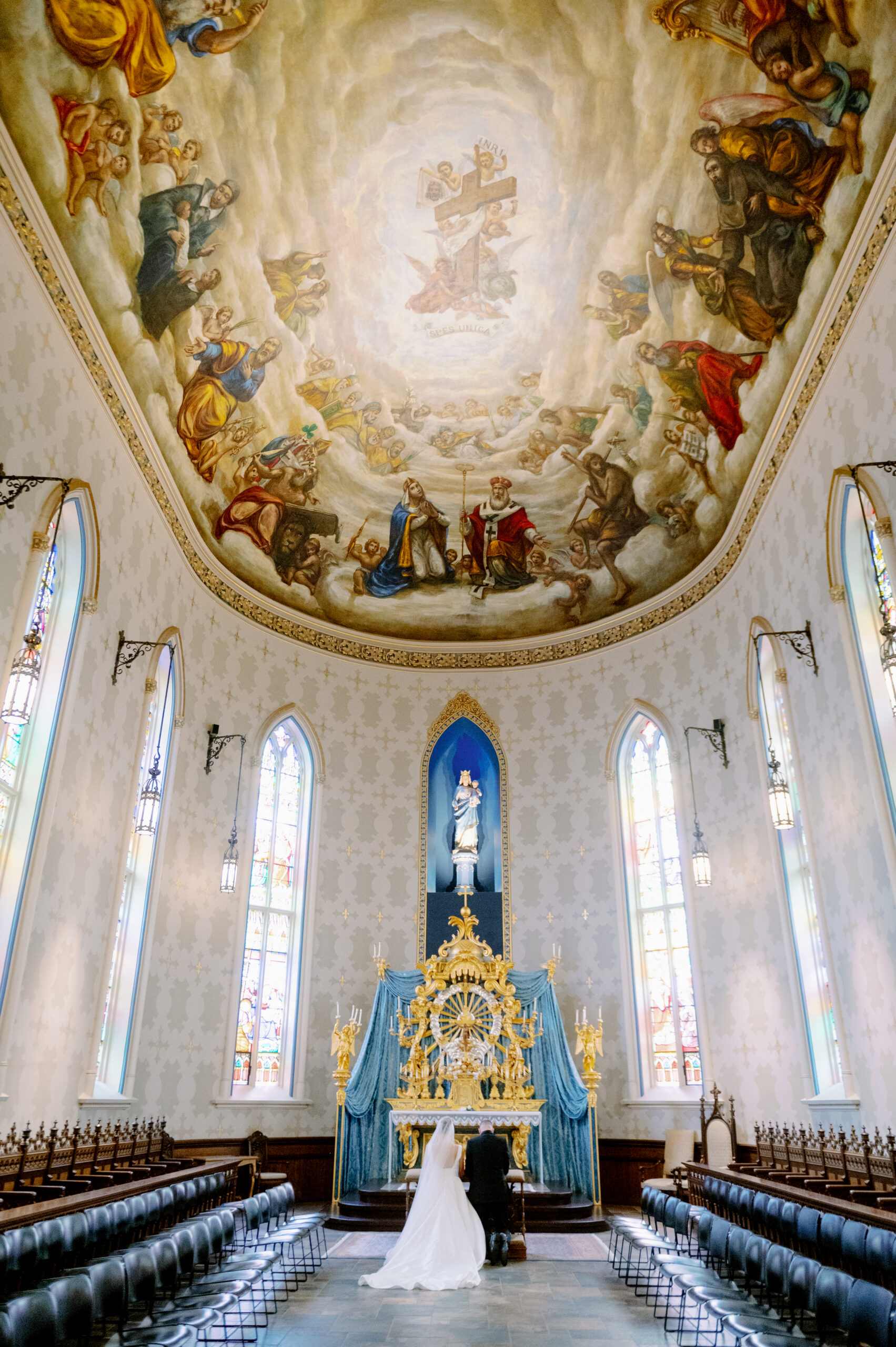 Basilica of Sacred Heart wedding ceremony showing ornate ceiling fresco, golden altar, and bride walking down aisle
